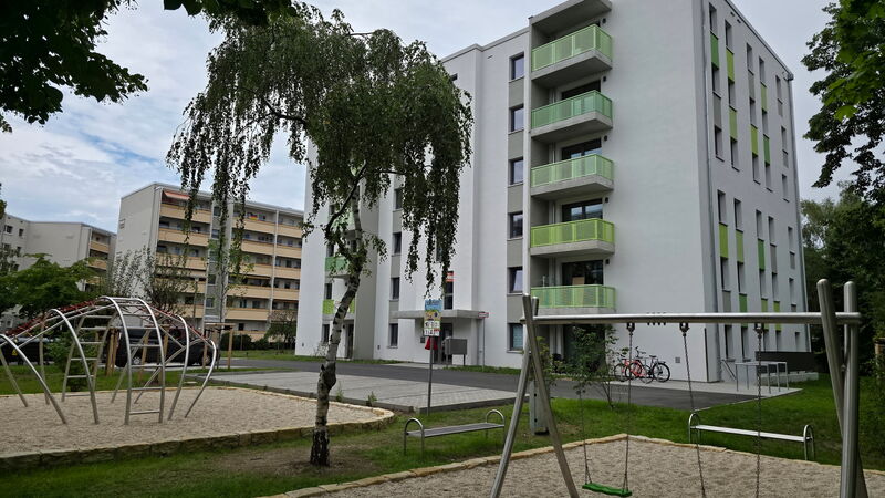fertiges Wohngebäude mit Spielplatz im Vordergrund